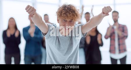 felice giovane dipendente che si trova di fronte al team aziendale Foto Stock