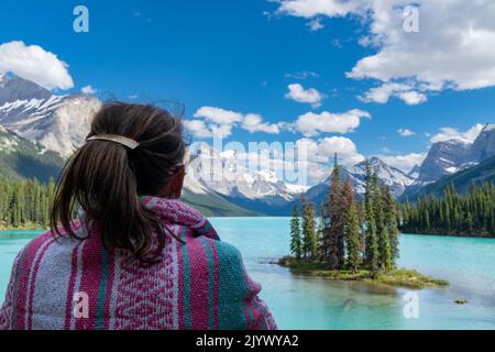 Donna vista Spirit Island dalla costa del lago Maligne nel Jasper National Park Foto Stock