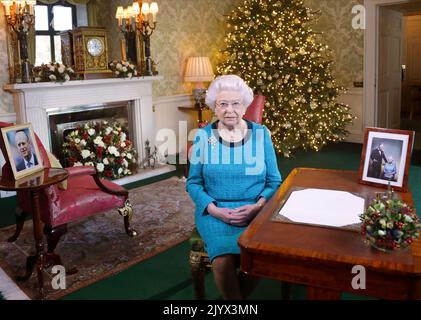 Foto del file datata 25/12/2016 della Regina Elisabetta II seduta su una scrivania nella Regency Room a Buckingham Palace, Londra, dopo aver registrato la trasmissione del suo giorno di Natale al Commonwealth. La regina morì pacificamente a Balmoral questo pomeriggio, Buckingham Palace ha annunciato. Data di emissione: Giovedì 8 settembre 2022. Foto Stock