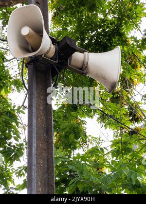 Il vecchio megafone è appeso al palo della cuccetta vicino alla piattaforma per gli annunci nella stazione urbana, sopra la vista con lo spazio di copia. Foto Stock