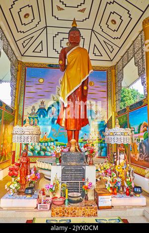 PAI, THAILANDIA - 6 MAGGIO 2019: Interno del santuario del tempio di Wat Pa Kham con una statua di Buddha in piedi con pareti dipinte e soffitto intorno ad esso, o Foto Stock