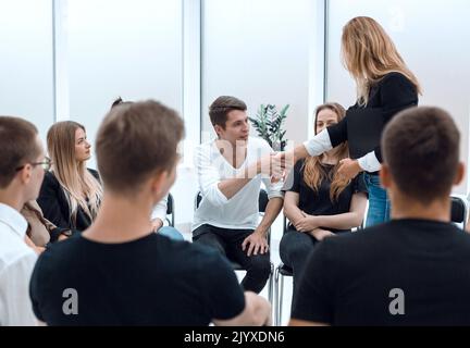 Giovane donna conduce attività di formazione con un gruppo di giovani. Foto Stock