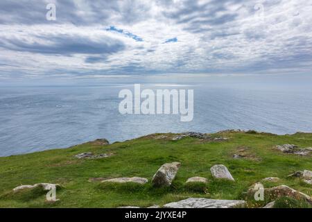 Un cielo suggestivo e vedute lontane dell'Isola di Norterna dal Mull of Oa, a sud di Islay, un'isola scozzese Foto Stock