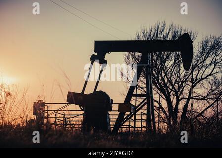 Una pompa di olio jack nella zona rurale del Texas al tramonto al di fuori della contea di Montague. Foto Stock