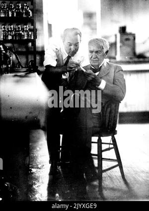 ***** Candid Camera's Eye vede il grande inventore ***** In Work in Laboratory - la fotografia di cui sopra, fatta senza la conoscenza dei soggetti, mostra Thomas A. Edison, anziano ***** , Conferendo con il suo assistente George Hart, ***** uno dei loro numerosi esperimenti sulla gomma. La foto fatta con la fotocamera candida, è stata scattata nel ***** di Edison Orange ed è una delle migliori foto di Edison in molti anni. Luglio 11, 1930. (Foto di International newsreel Photo). Foto Stock