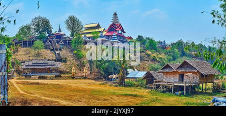 Il piccolo villaggio palafitte casa ai piedi della collina e il Wat Tham Poo SA ma Tempio in cima alla collina, Mae Hong Son sobborgo, Thailandia Foto Stock
