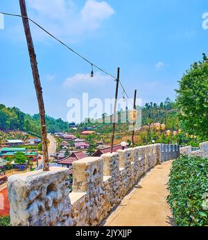 Carta lanterne cinesi decorare il muro di pietra fortezza del villaggio del tè Yunnan di Ban Rak Thai, Thailandia Foto Stock
