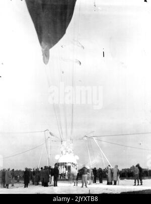 Piccards off per Stratosphere -- quasi 250 uomini erano nel troupe di terra che preparava la palloncino stratosphere del Prof. e della Sig.ra Jean Piccard a Detroit, Michigan, per il loro lungo volo in alto aria. La foto mostra l'equipaggio in procinto di rilasciare la mongolfiera la mattina presto del 23 ottobre, presso l'aeroporto ford, vicino a Detroit. La mongolfiera salì verso est e atterrò vicino a Cadice, Ohio. Né le Piccards né i loro strumenti sono stati feriti. Ottobre 23, 1934. (Foto per foto stampa associata). Foto Stock