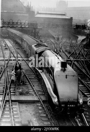 La prima delle locomotive snellite 'Coronation' parte da Londra in First Run - la 'Golden Engle' lascia King's Cross alla testa dell'espresso scozzese in prima corsa. Prima delle nuove locomotive di tipo super-Pacifico snellite destinate a funzionare la 'incoronazione' da record esprime più tardi nell'anno, la 'Golden Eagle' lasciò King's Cross Station, Londra, alla sua prima esecuzione. La locomotiva stava trascinando il London Edinburgh Express - uno dei treni più pesanti e veloci del giorno - fino a Neweastle. Gennaio 6, 1937. Foto Stock