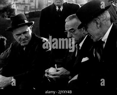 I capitani della Coppa Davis non giocanti Gerald Patterson (Australia) se ne andarono, e Walter Pate (Stati Uniti), al centro, discutono della marca della palla da tennis da utilizzare nel Challenge Round con IL presidente ALTA, Sir Norman Brookes. Novembre 24, 1946. Foto Stock