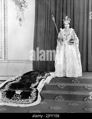 Foto del file datata 02/06/53 della Regina Elisabetta II indossando l'abito di incoronazione nella stanza del Trono a Buckingham Palace, dopo la sua incoronazione nell'Abbazia di Westminster. L'incoronazione della Regina, ricca di significato religioso, è stata un impulso morale per una nazione affamata di trageantry dalla guerra, e per un giorno le feste di strada hanno bandito le difficoltà del razionamento e delle carenze e anche il tempo atrocio e non stagionale non ha smorzato l'entusiasmo. Data di emissione: Giovedì 8 settembre 2022. Foto Stock