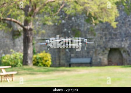 Piccolo drone che vola all'interno del castello di Caldicot, Church Road, Caldicot, Monmouthshire, Galles (Cymru), Regno Unito Foto Stock