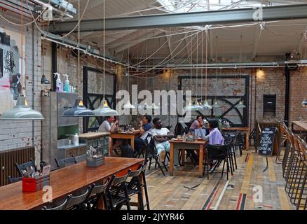 Mackie Mayor interni, tavoli da pranzo comuni, campo da cucina informale, Smithfield Market Hall, 1 Eagle St, Manchester M4 5BU Foto Stock