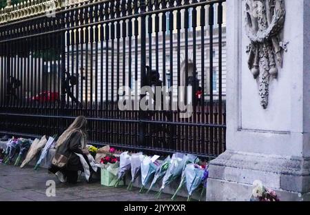 Londra, Regno Unito. 08th Set, 2022. Una donna ha visto posare i fiori sulla porta del Buckingham Palace come un addio alla regina Elisabetta II Migliaia di persone si sono radunate fuori da Buckingham Palace nel centro di Londra dopo l'annuncio della morte della Regina Elisabetta II La regina Elisabetta II era il monarca più lungo al servizio del Regno Unito. Morì all'età di 96 anni. Credit: SOPA Images Limited/Alamy Live News Foto Stock
