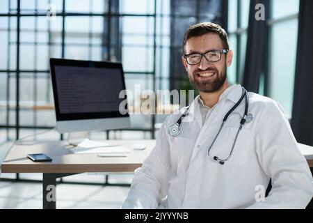 Felice giovane uomo medico sorridere bello Foto Stock