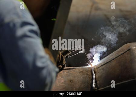 Bucarest, Romania - 8 settembre 2022: Profondità di campo poco profonda (fuoco selettivo) dettagli con una saldatrice professionale saldatura di un pip metallico industriale Foto Stock