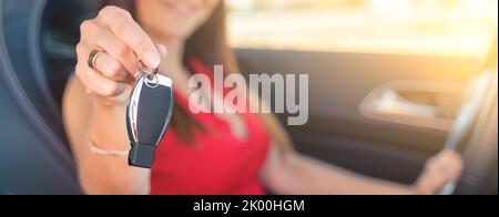 Vendita di auto donna che consegna a un cliente la chiave per un test drive - il noleggio di auto e il concetto di vendita di auto - focus selettivo Foto Stock