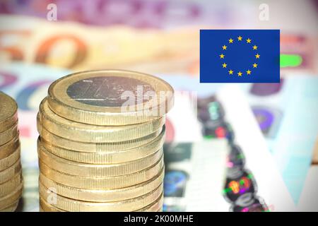 Banconote e monete in euro con bandiera europea. Foto Stock