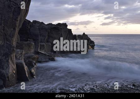 Formazione di rocce vulcaniche al crepuscolo, spiaggia di Praia Formosa vicino a Funchal Madeira Portogallo. Foto Stock