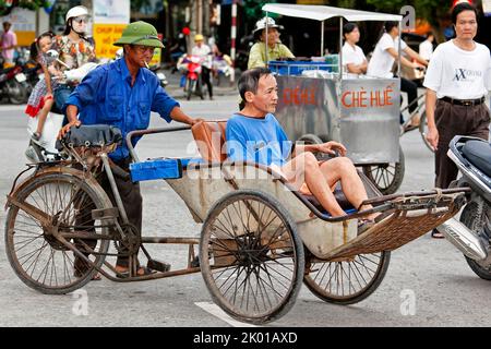 Bicicletta vietnamita risciò, pilota e passeggero nel traffico, Hai Phong, Vietnam Foto Stock