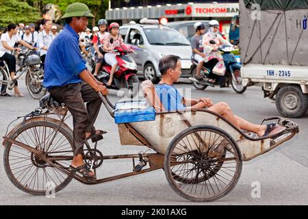 Bicicletta vietnamita risciò, pilota e passeggero nel traffico, Hai Phong, Vietnam Foto Stock