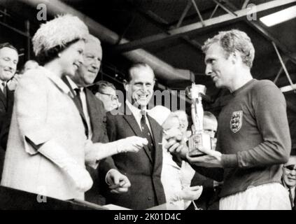 La regina Elisabetta II premia il trofeo Jules Rimet a Sir Bobby Moore, capitano della squadra di calcio inglese vincitrice della Coppa del mondo al Wembley Stadium nel 1966. Foto Stock