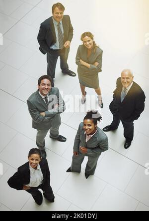Weve ha ottenuto i nostri punti di vista su nuove altezze. Ritratto ad angolo alto di un gruppo di uomini d'affari in piedi nella lobby dell'ufficio. Foto Stock