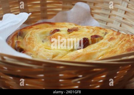 Fresca e croccante Raisin rotola nel cestino colazione continentale nel caffè francese Macaronnerle a Heidelberg. Primo piano, macro, vista laterale Foto Stock