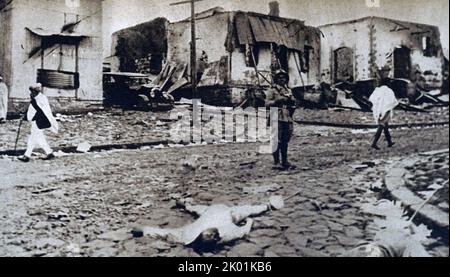 Dopo sette mesi di combattimenti, l'Italia annette l'Abissinia dopo che le truppe avevano marciato ad Addis Abeba il 5 maggio 1936. Un soldato italiano tiene la guardia mentre il corpo di un 'saccheggiante' abissino si trova a terra. Foto Stock