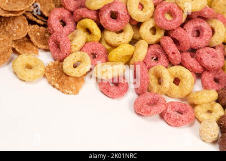 Cereali da mais sotto forma di anelli multicolore su sfondo bianco. Foto Stock