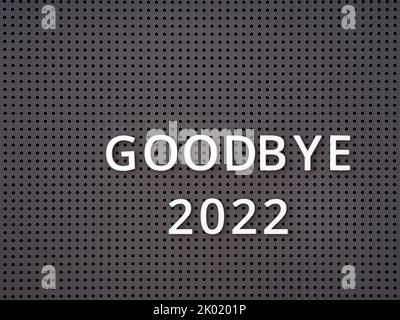 Parole Arrivederci 2022 scritto con lettere bianche su un pegboard grigio Foto Stock