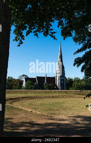 Chiesa di Sant'Alban (Chiesa inglese) a Copenaghen, Danimarca incorniciata dal tronco dell'albero e dai rami Foto Stock