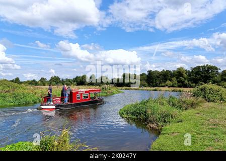 Una barca stretta solita che naviga sul canale di navigazione River Wey vicino Ripley in un giorno estivo Surrey Inghilterra UK Foto Stock