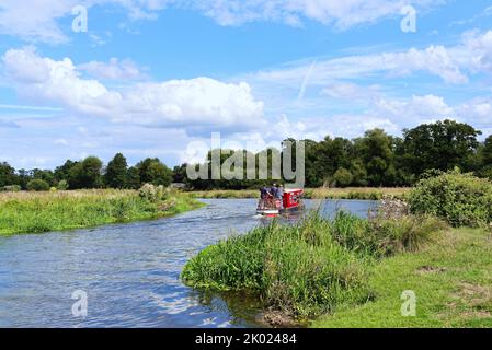 Una barca stretta solita che naviga sul canale di navigazione River Wey vicino Ripley in un giorno estivo Surrey Inghilterra UK Foto Stock