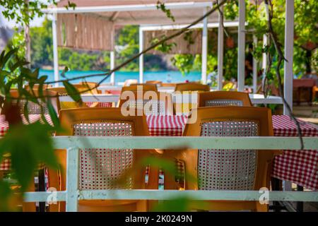 Tavoli e sedie sulla terrazza estiva del ristorante. Semplici mobili in plastica del ristorante nella regione del resort in Turchia. Foto Stock