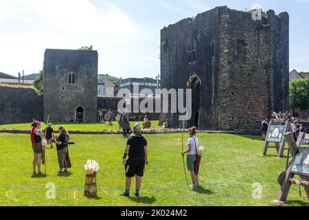 Tiro con l'arco e combattimento con la spada all'interno del castello di Caerphilly, Caerphilly (Caerffili), Caerphilly County Borough, Galles (Cymru), Regno Unito Foto Stock