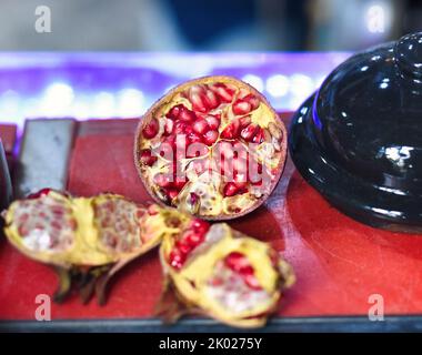 Frutta melograna matura sbucciata su un tavolo Foto Stock