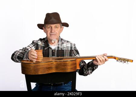 Attraente vecchio con chitarra e la tipica infusione in Argentina e Uruguay chiamato Mate Foto Stock