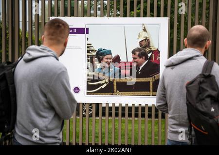 Varsavia, Polonia. 09th Set, 2022. Gli uomini guardano l'immagine della regina Elisabetta II e dell'ex presidente Lech Walesa impiccato sulla recinzione dell'ambasciata britannica a Varsavia. Dopo l'annuncio della morte di sua Maestà la Regina Elisabetta II, dalla mattina i cittadini di Varsavia lasciano fiori e candele per rendere omaggio a sua Maestà presso l'Ambasciata britannica di Varsavia. Credit: SOPA Images Limited/Alamy Live News Foto Stock