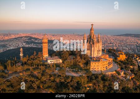 Vista aerea dello skyline di Barcellona con il tempio Sagrat Cor al tramonto, Catalogna, Spagna Foto Stock