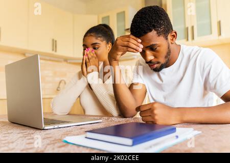 Stressato afro americano coppia guardando frustrato dopo aver ottenuto una cattiva notizia dalla famiglia Foto Stock