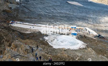 Pista di ghiaccio fatta di relitti di neve accanto ai resti del ghiacciaio Schmiedingerkees sul monte Kitzsteinhorn, in estate, Austria Foto Stock