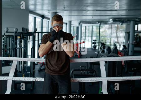 Pugile stanco con asciugamano nell'anello Foto Stock