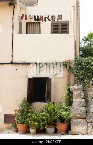 Scarpe sulla linea di chiusura sul balcone di una casa mediterranea Foto Stock