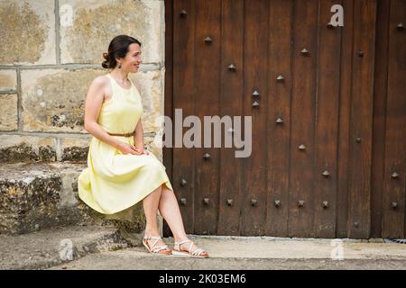 Ritratto lifestyle di giovane donna elegante che cammina sulla strada nella città vecchia Foto Stock