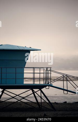 Torre del bagnino azzurro su una spiaggia in California, in una giornata nuvolosa e nebbia. Baywatch Foto Stock