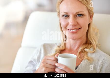 Rilassatevi con una cuppa. Ritratto di una donna che si gode una tazza di caffè a casa. Foto Stock