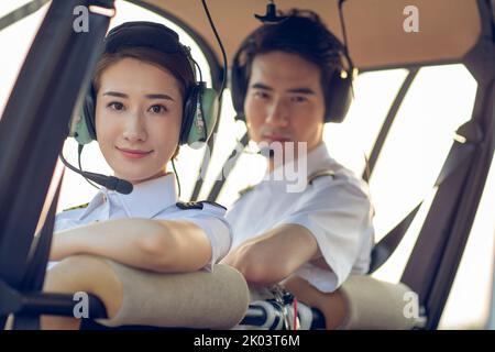 Piloti cinesi seduti in elicottero Foto Stock