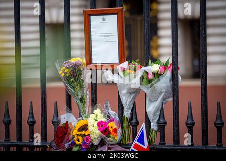 Buckingham Palace, Londra, Regno Unito – Venerdì 9th settembre 2022 – Fiori e bandiere ora circondano l'avviso ufficiale di morte della Regina Elisabetta II fuori Buckingham Palace.Photo Horst A. Friedrichs Alamy Live News Foto Stock