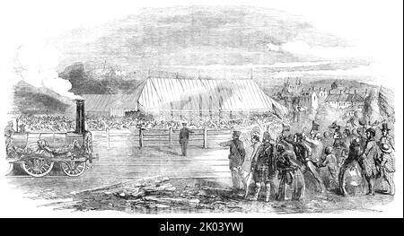 Apertura della Great North of Scotland Railway - The Huntly Station, 1854. La gente del posto si ritrova per l'arrivo del primo treno a vapore nella loro città. "L'apertura formale di questa linea, che estende la comunicazione ferroviaria a quaranta miglia a nord di Aberdeen, in tutto il regno, ma in un collegamento ininterrotto con il grande sistema ferroviario, ha avuto luogo... il treno speciale partì da Kittybrewster, Aberdeen, alle undici... costituito da venticinque carrozze, trainate da due motori, e contenente i direttori e funzionari della linea, con un certo numero di altri signori, per un totale di circa 400.. Foto Stock